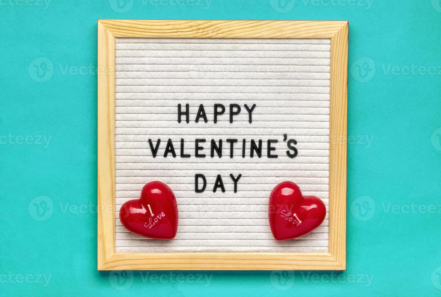 texto feliz día de san valentín en tablero de fieltro, velas rojas en forma de corazón sobre fondo azul vista superior tarjeta de vacaciones plana, concepto de amor foto