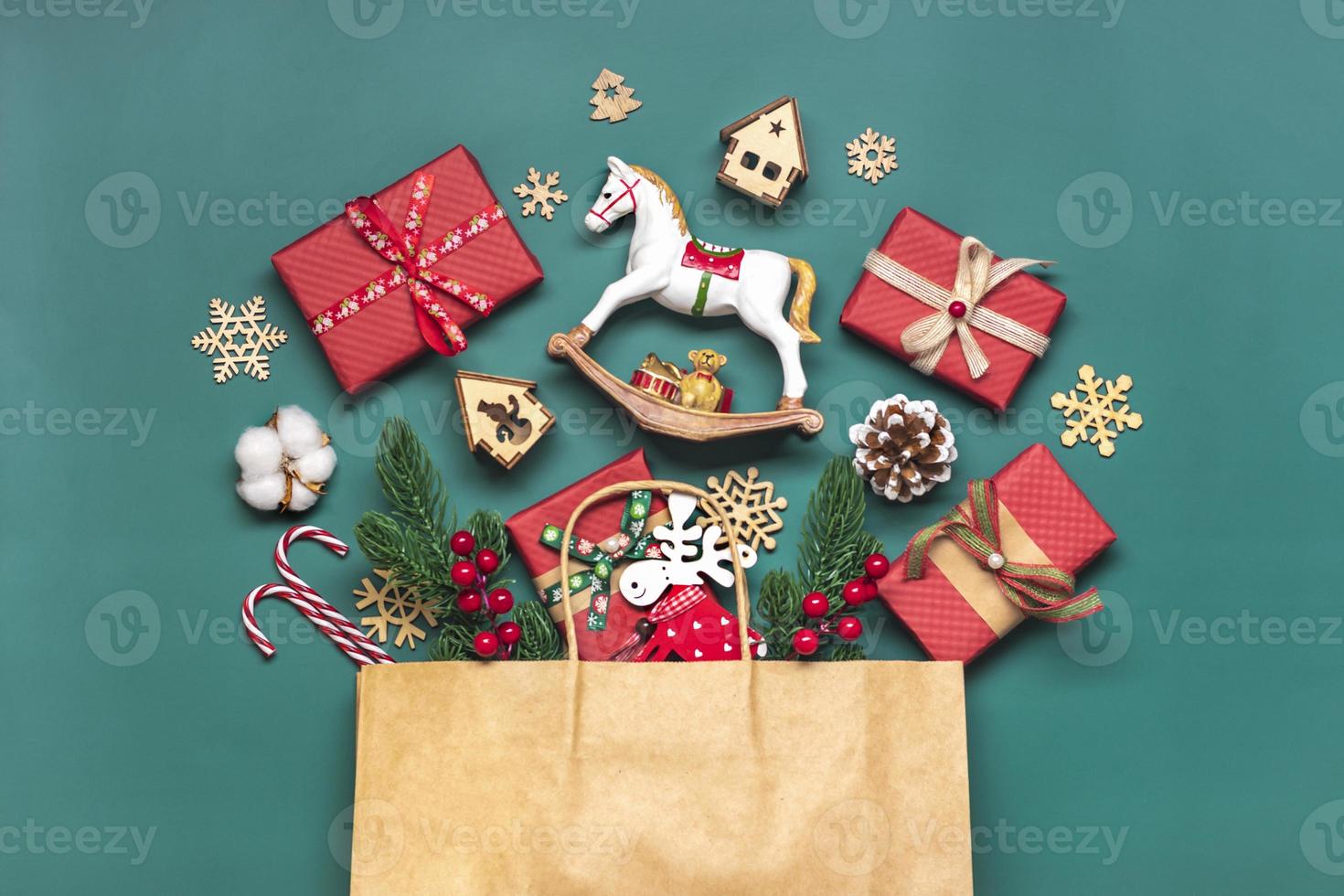 Handmade wrapped red gift boxes decorated with ribbons, snowflakes and numbers, Christmas decorations and decor in bag on green table Xmas advent calendar concept Top view Flat lay Holiday card photo