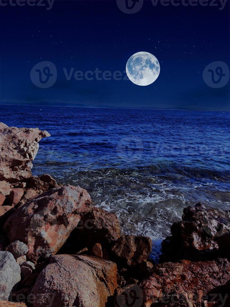 full moon on red sea and mountains photo