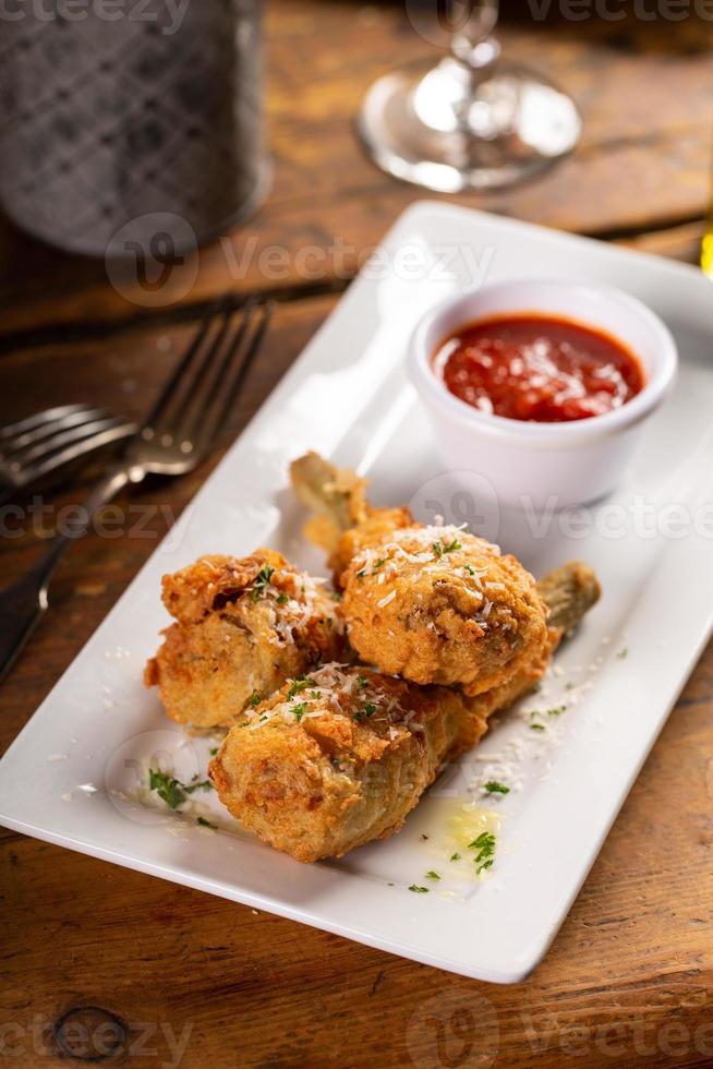 Fried lamb chops in parmesan batter with tomato sauce photo