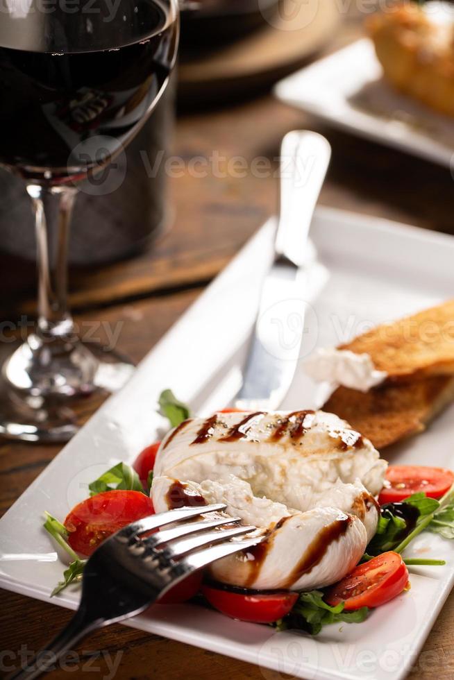 plato de aperitivo italiano con burrata y prosciutto foto