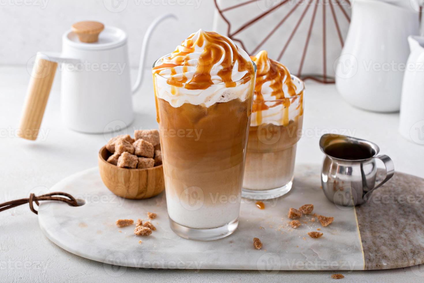 Iced caramel latte topped with whipped cream and caramel sauce photo