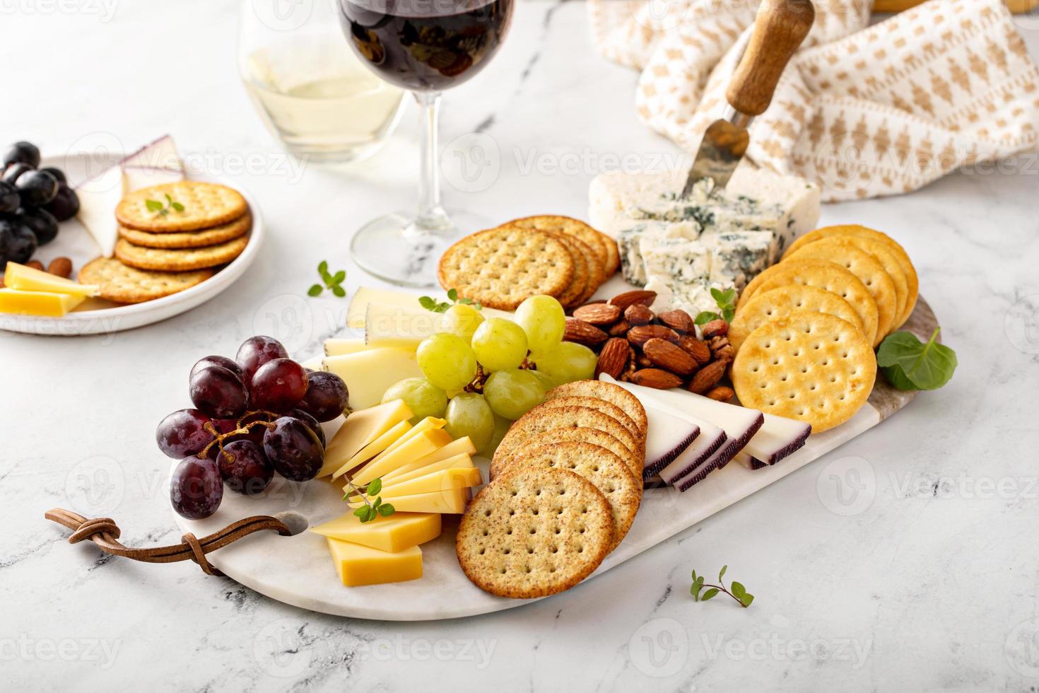 tabla de quesos con galletas, nueces y uvas foto