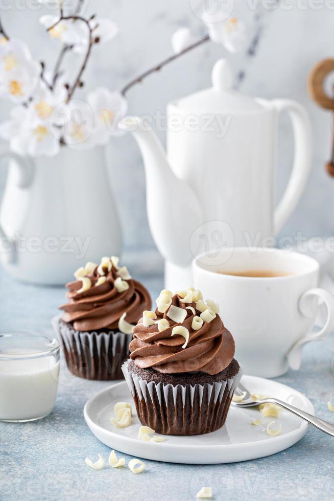 Dark chocolate cupcakes with whipped ganache frosting and white chocolate curls photo