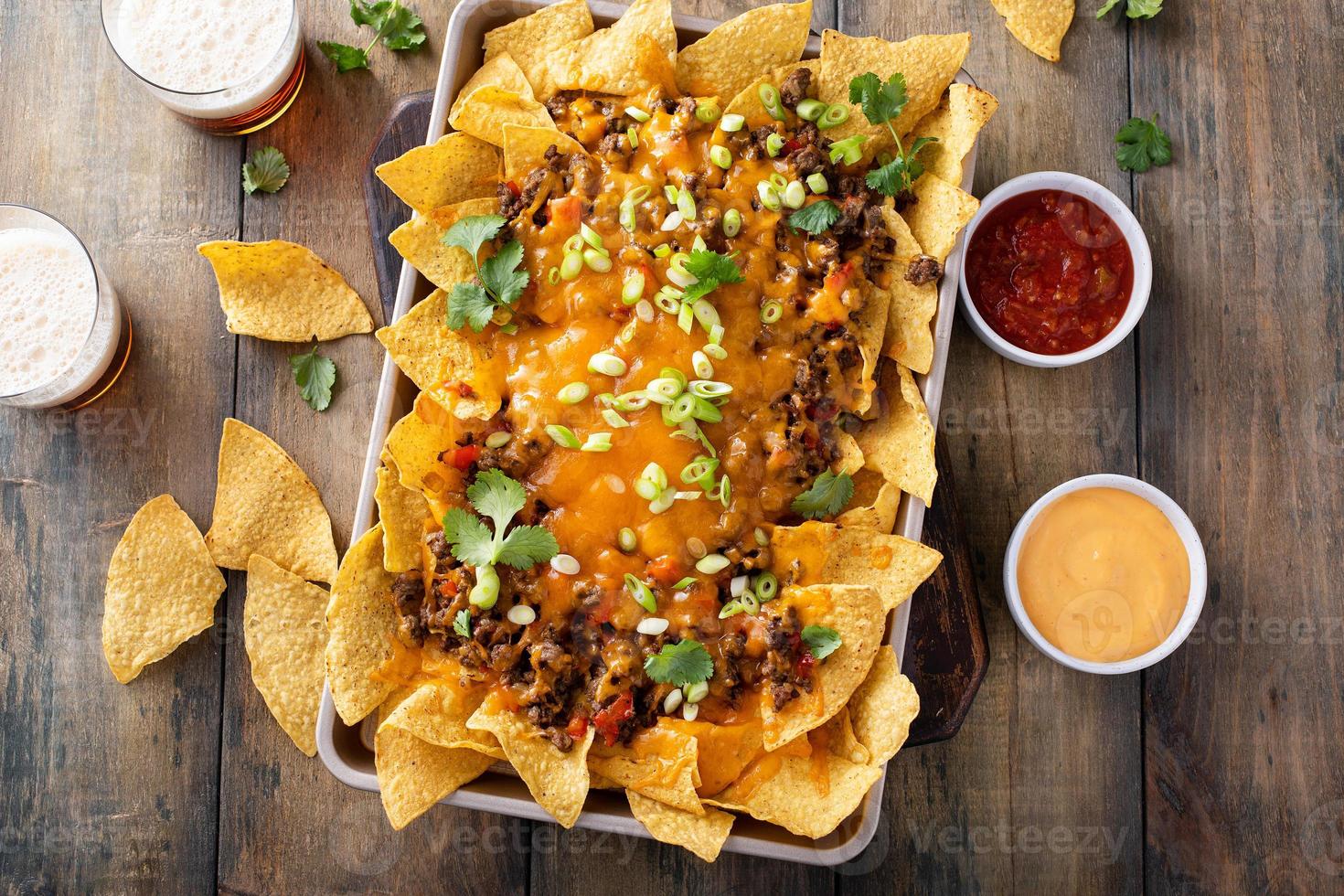 Traditional nachos with ground beef and red pepper photo