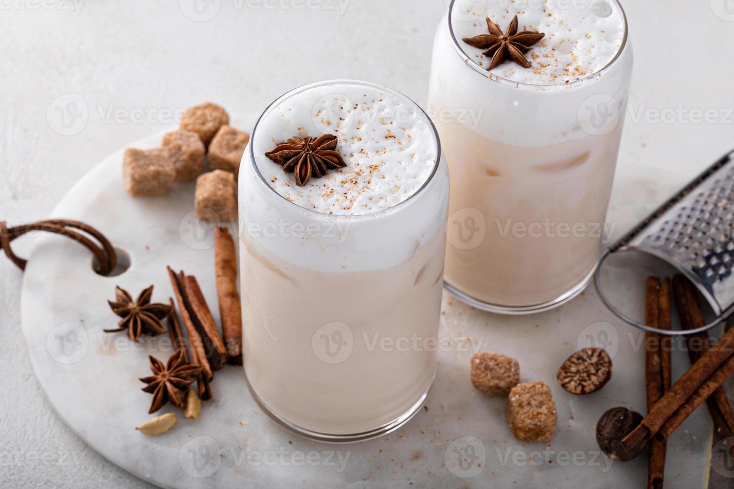 Iced chai latte with warm winter spices topped with milk foam photo
