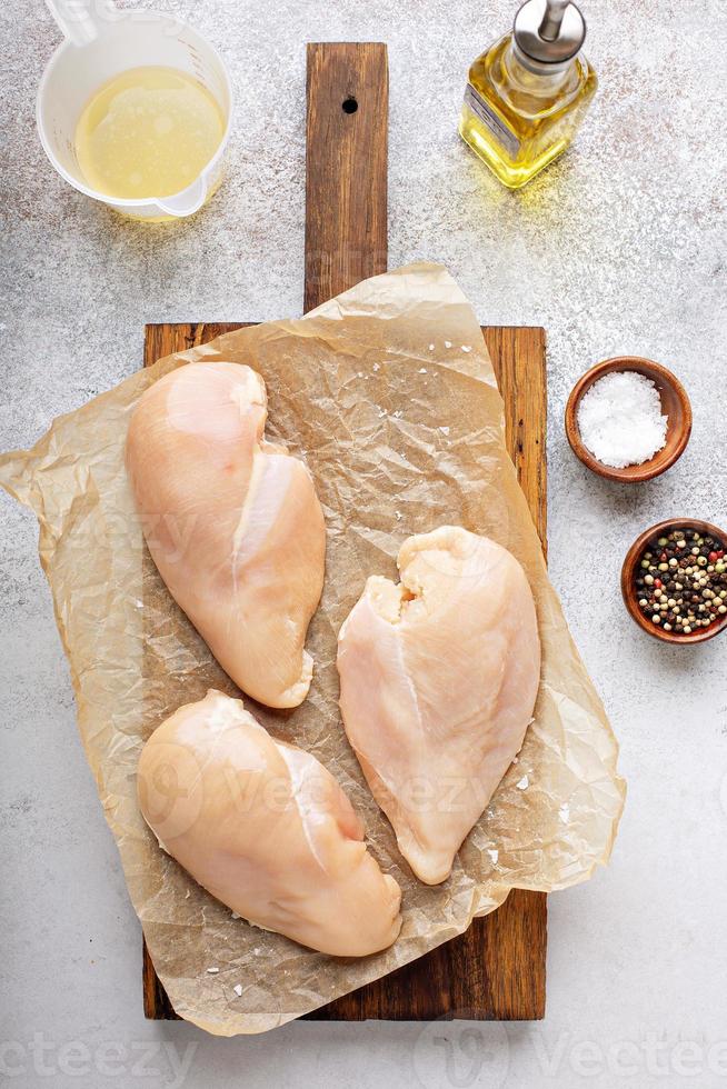 Raw chicken breast on a cutting board photo