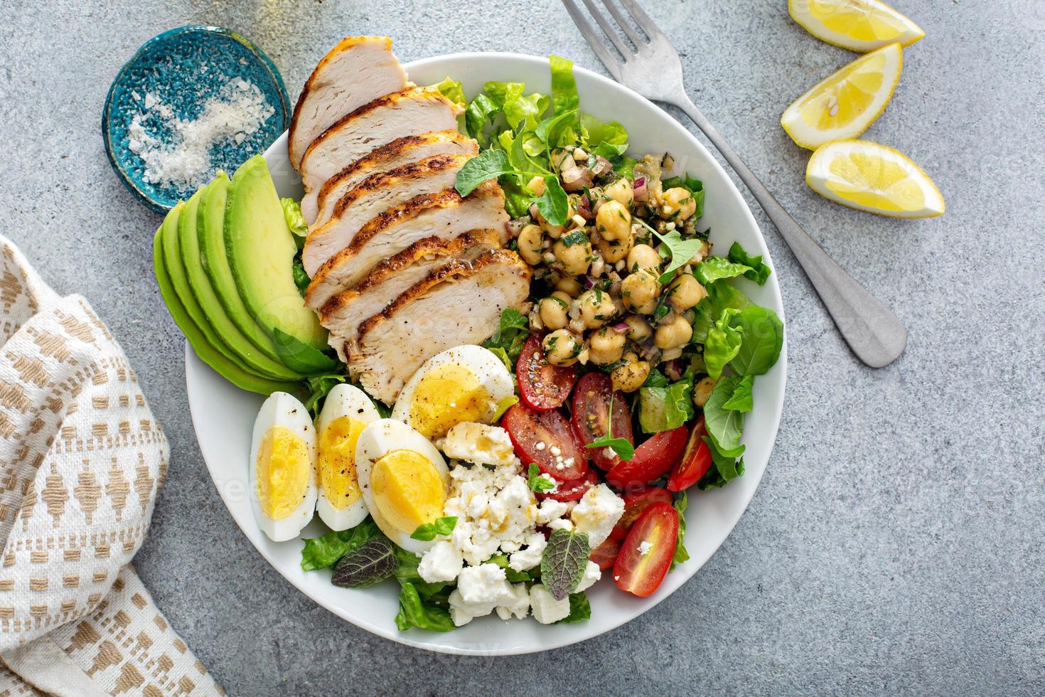 Tazón de almuerzo de ensalada saludable con pollo, aguacate y garbanzos foto