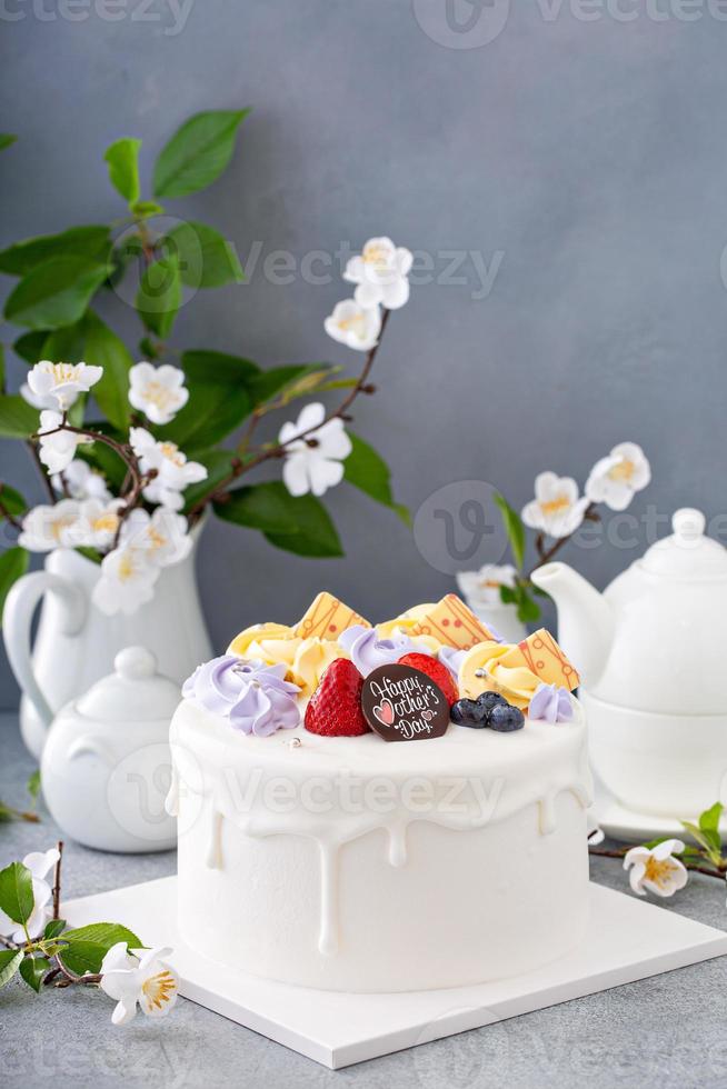 bizcocho de vainilla para el día de la madre con flores y glaseado de chocolate blanco foto