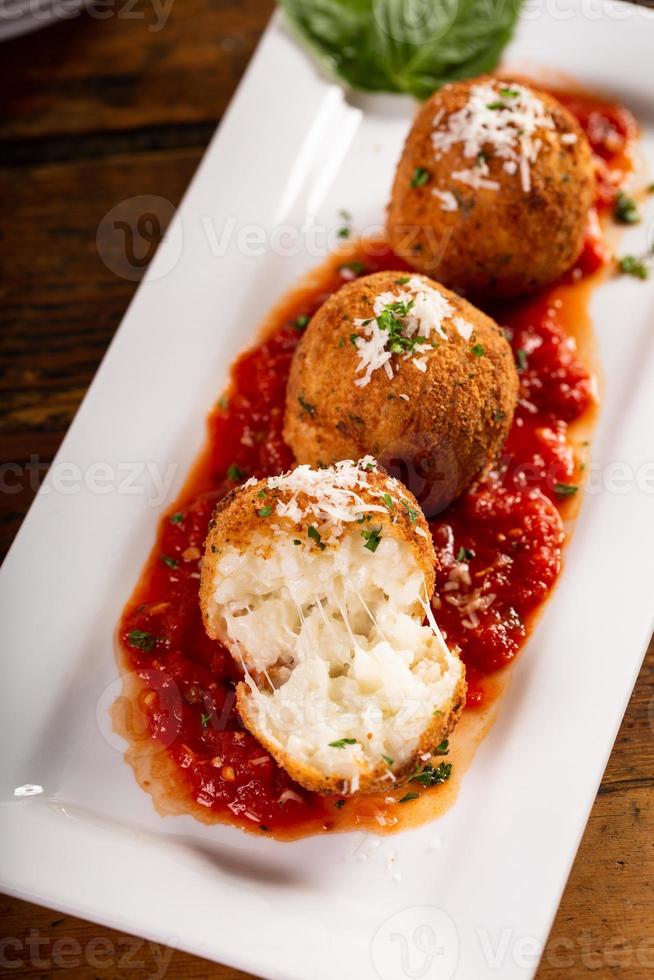 arancini, bolas de arroz italianas rellenas cubiertas con pan rallado foto