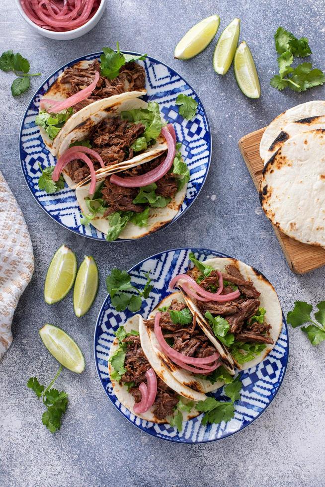 Beef tacos with lettuce and pickled red onion photo