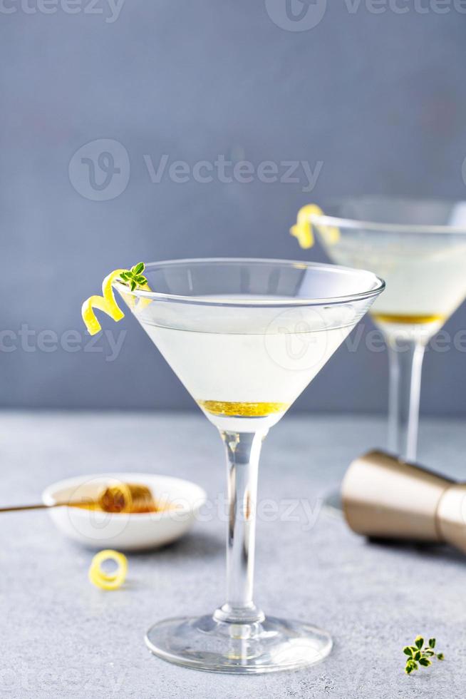 Martini con gota de limón, miel y tomillo con guarnición foto