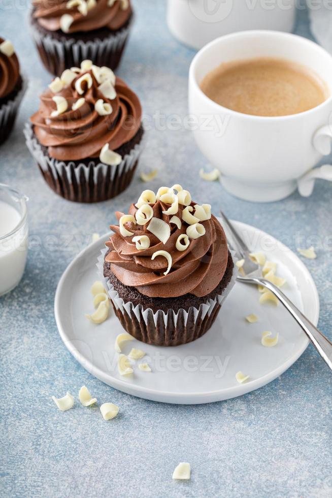 Dark chocolate cupcakes with whipped ganache frosting and white chocolate curls photo