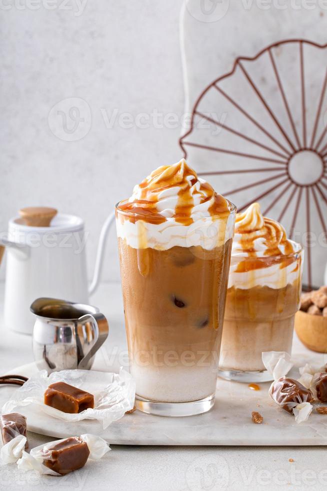 Iced caramel latte topped with whipped cream and caramel sauce photo