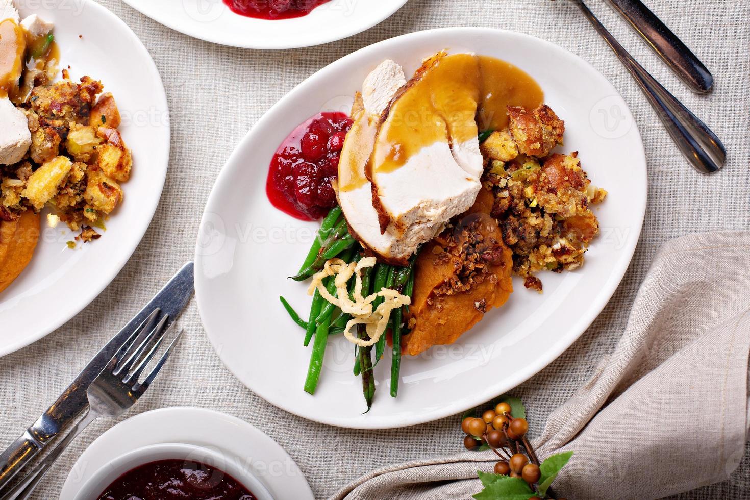 Festive Thankgiving dinner table with plates of food photo