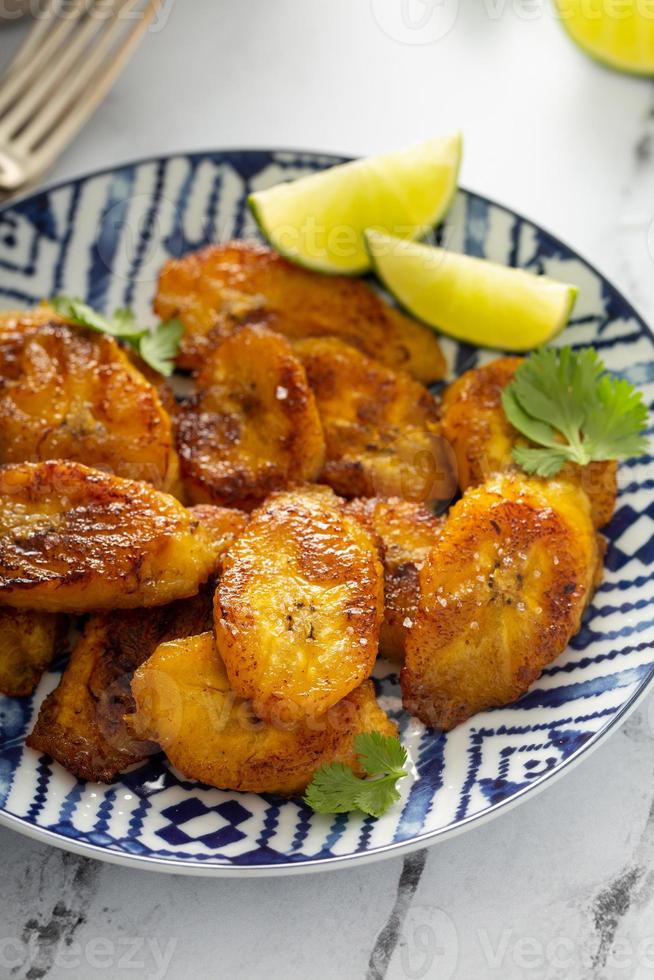 plátanos fritos caramelizados servidos con rodajas de lima foto