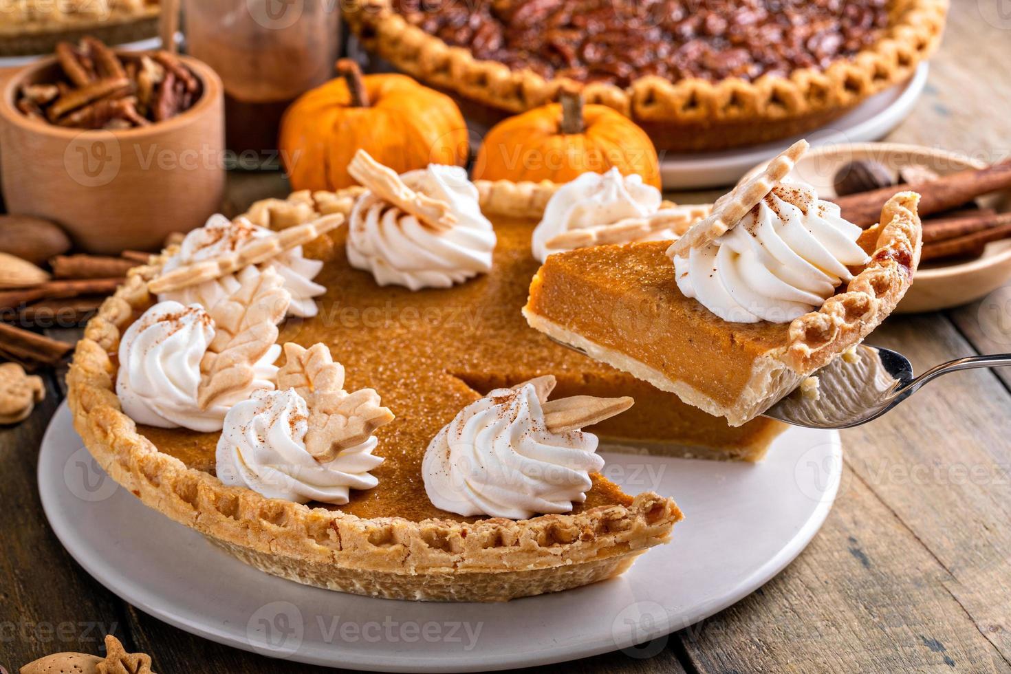 Traditional Thanksgiving pumpkin pie topped with whipped cream photo