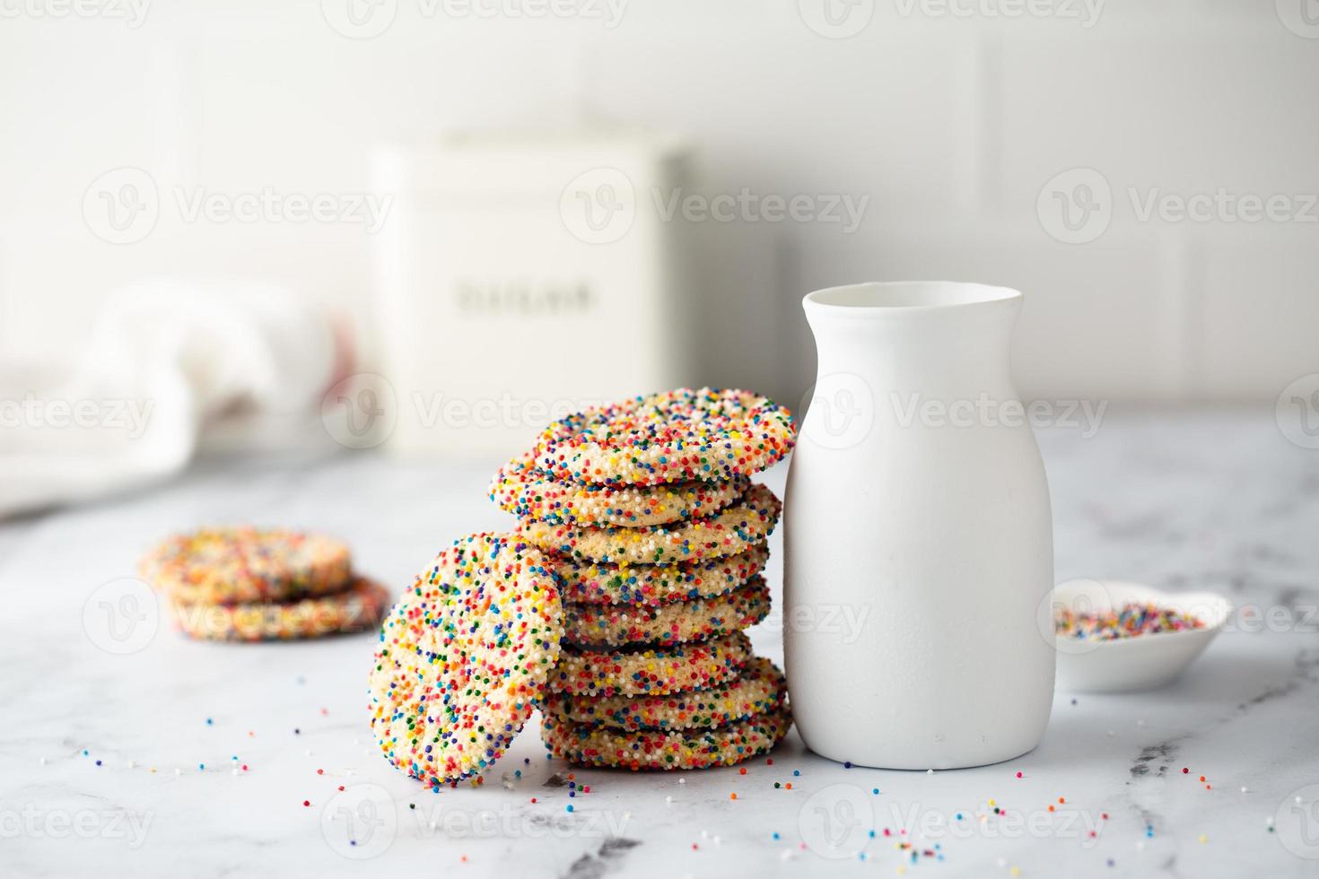 galletas de azúcar con chispas y una botella de leche foto