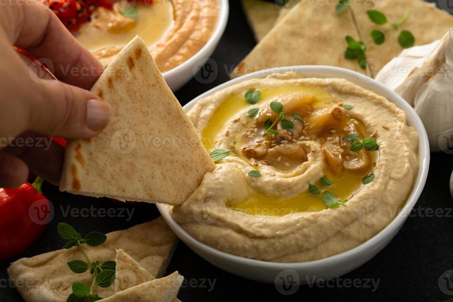 Roasted garlic hummus topped with olive oil photo