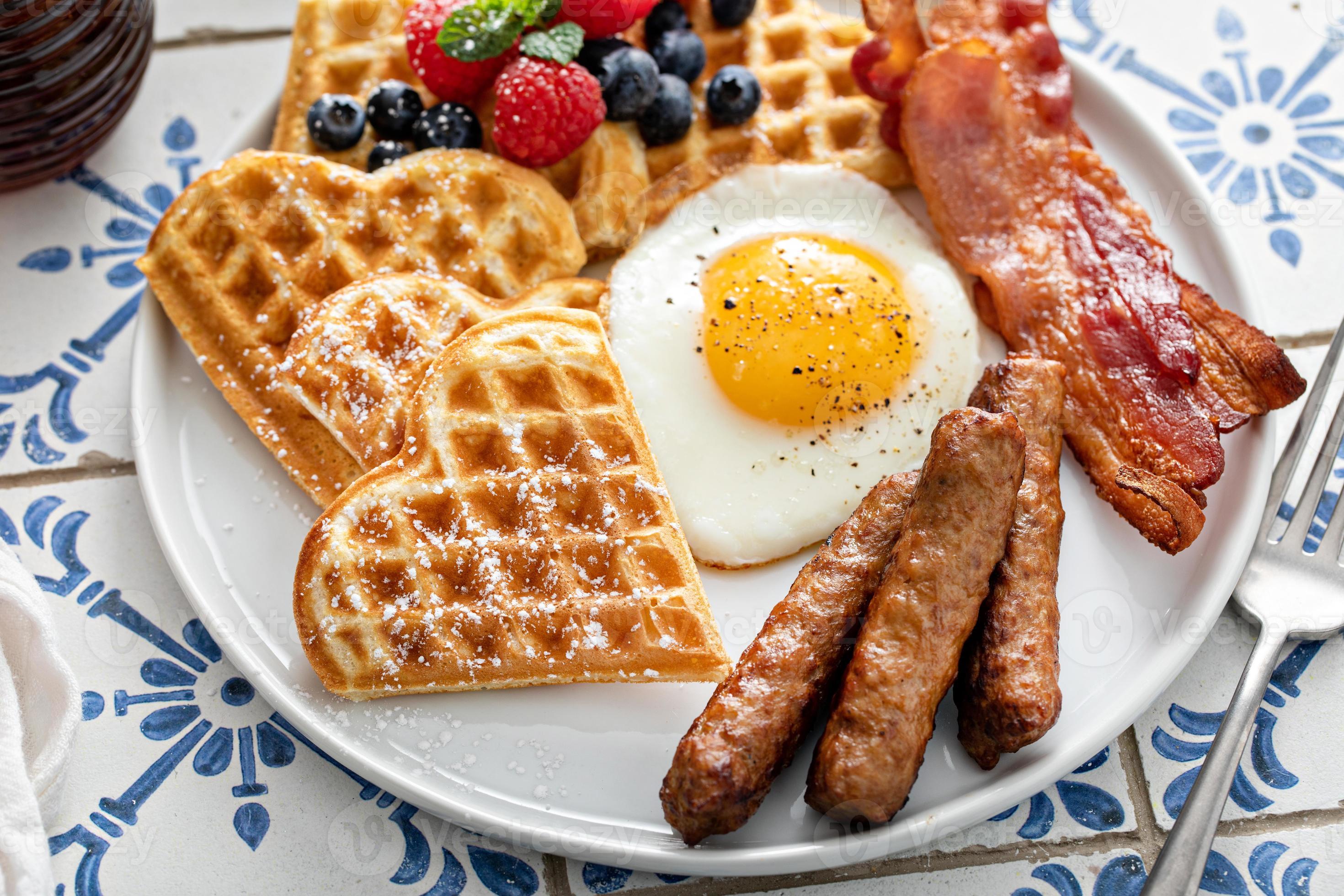 Breakfast table with waffles. fried egg, bacon and sausage 16231514