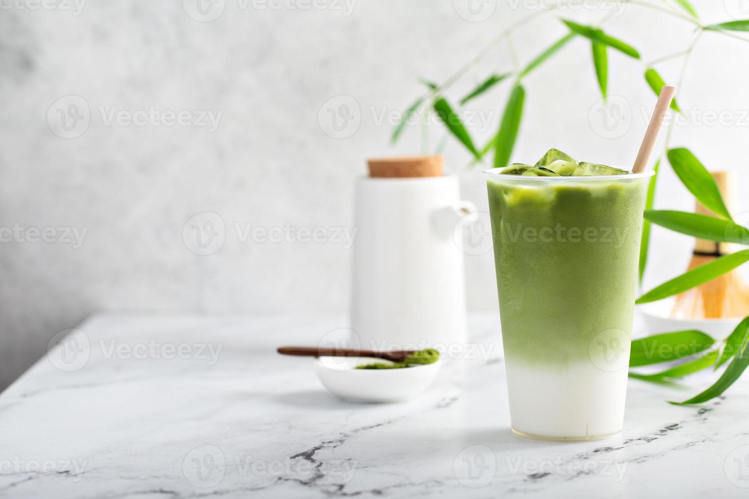 Cold matcha latte in a tall glass on marble photo