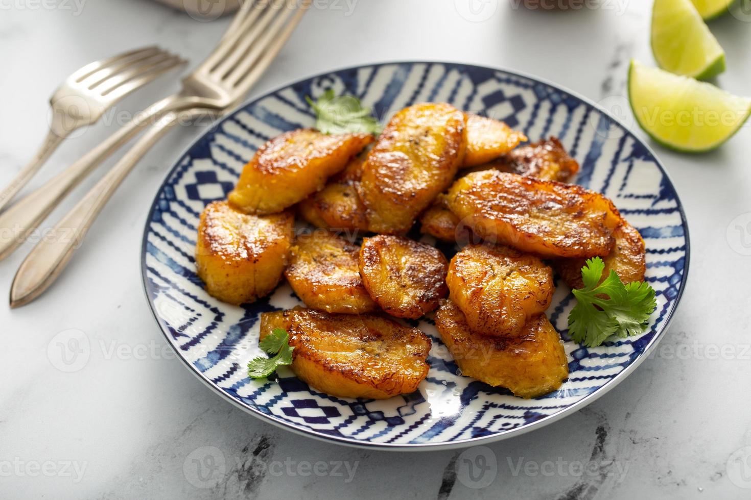 plátanos fritos caramelizados servidos con rodajas de lima foto