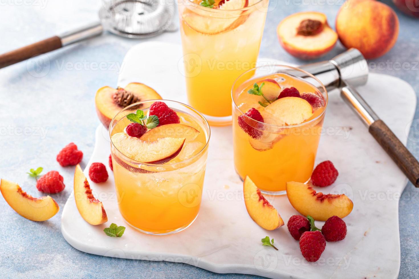 Refreshing summer cocktail with peach and raspberry photo