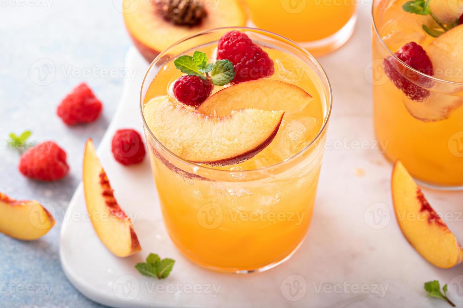 refrescante cóctel de verano con melocotón y frambuesa foto