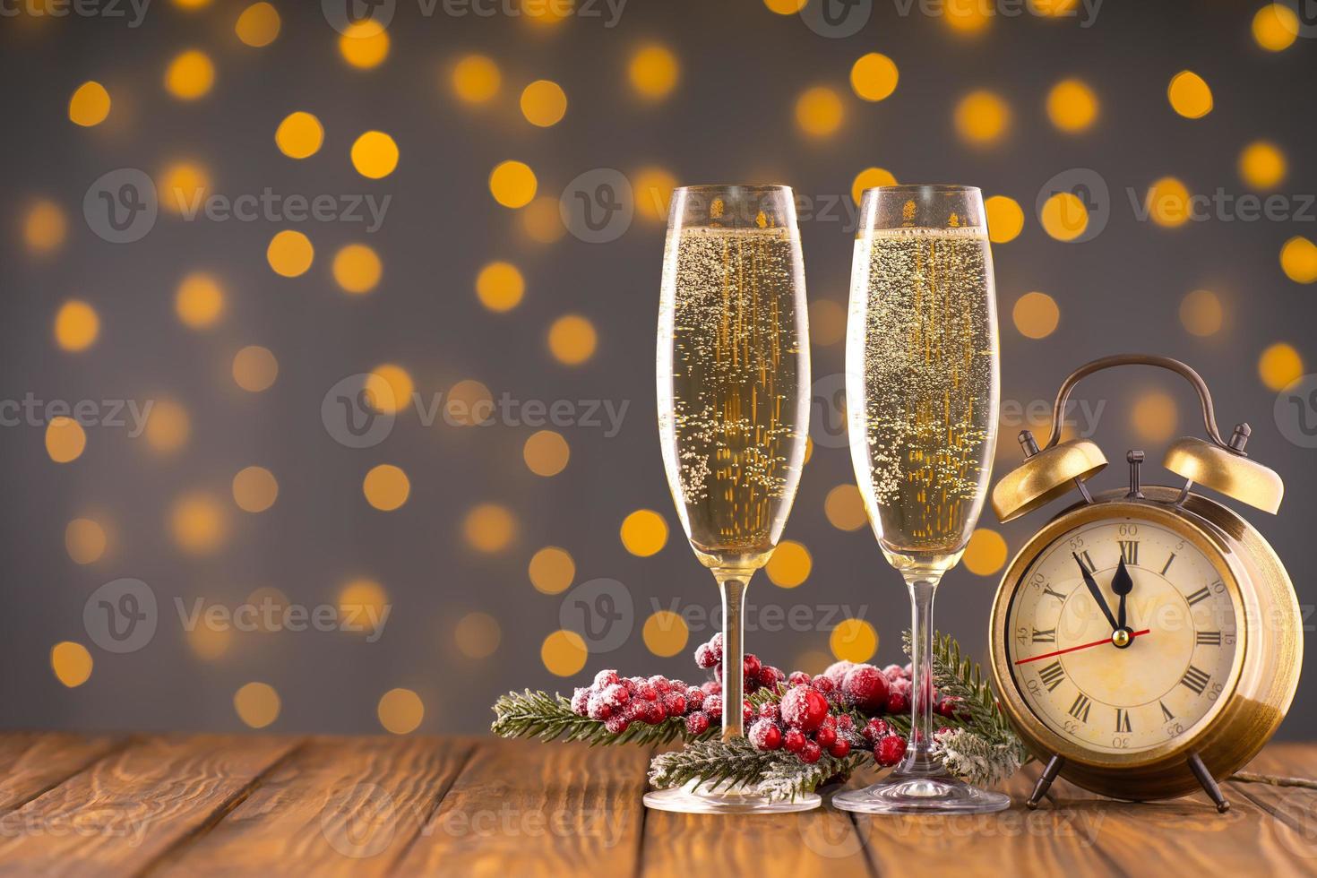 Two wine glasses with bubbly Champagne on blurry sparkling lights background photo