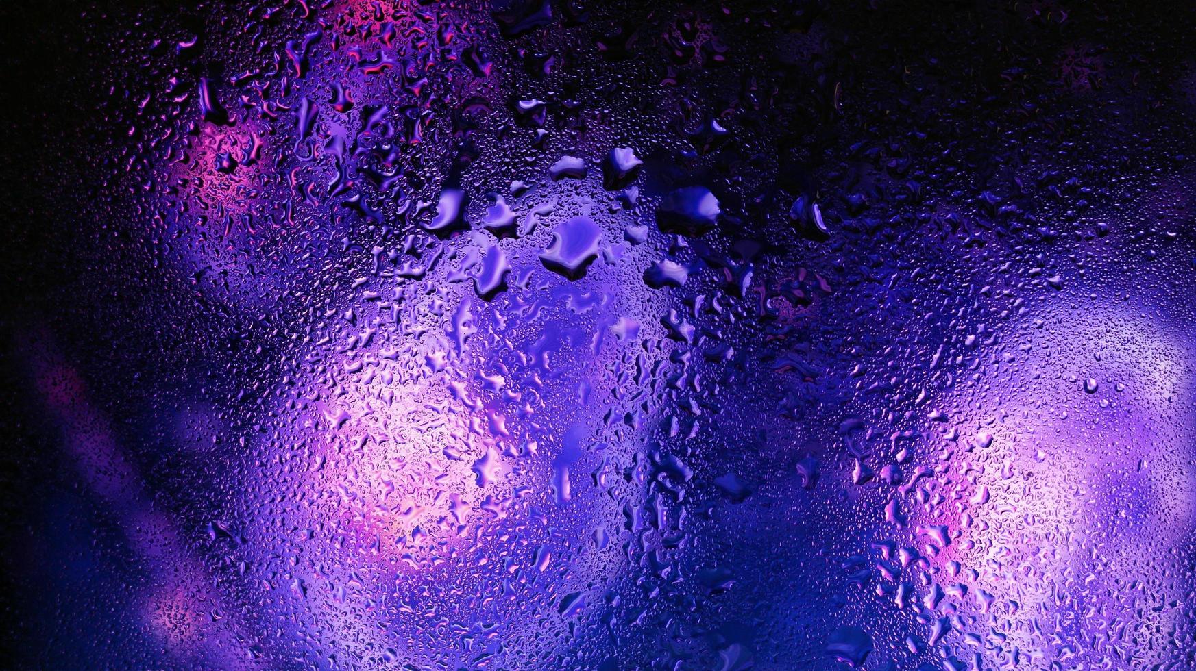 Purple Neon Blurred Lights Through Glass Window With Raindrops On It in Karachi Pakistan 2022 photo