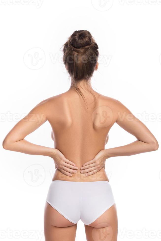 Woman with lower pain back against white background photo