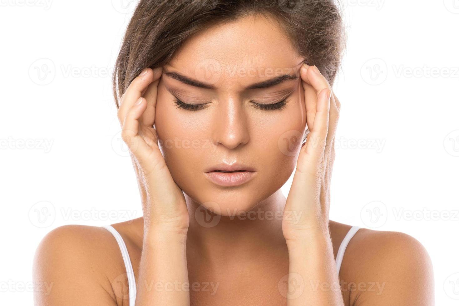 mujer con dolor de cabeza doloroso sobre fondo blanco foto