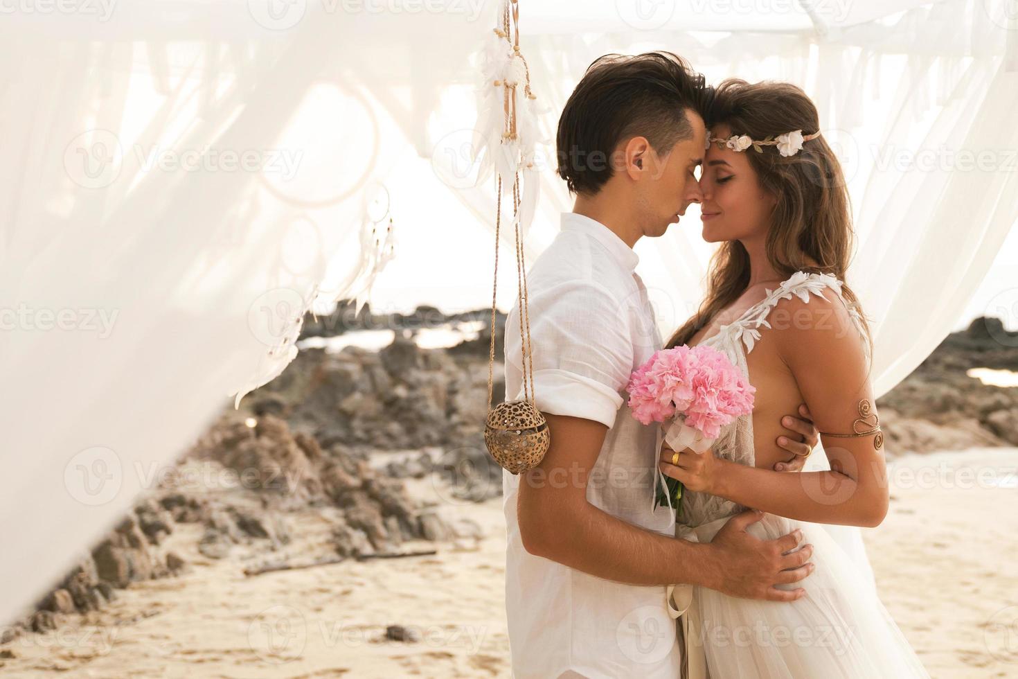 Happy married couple is celebrating their wedding on the beach at tropical island photo