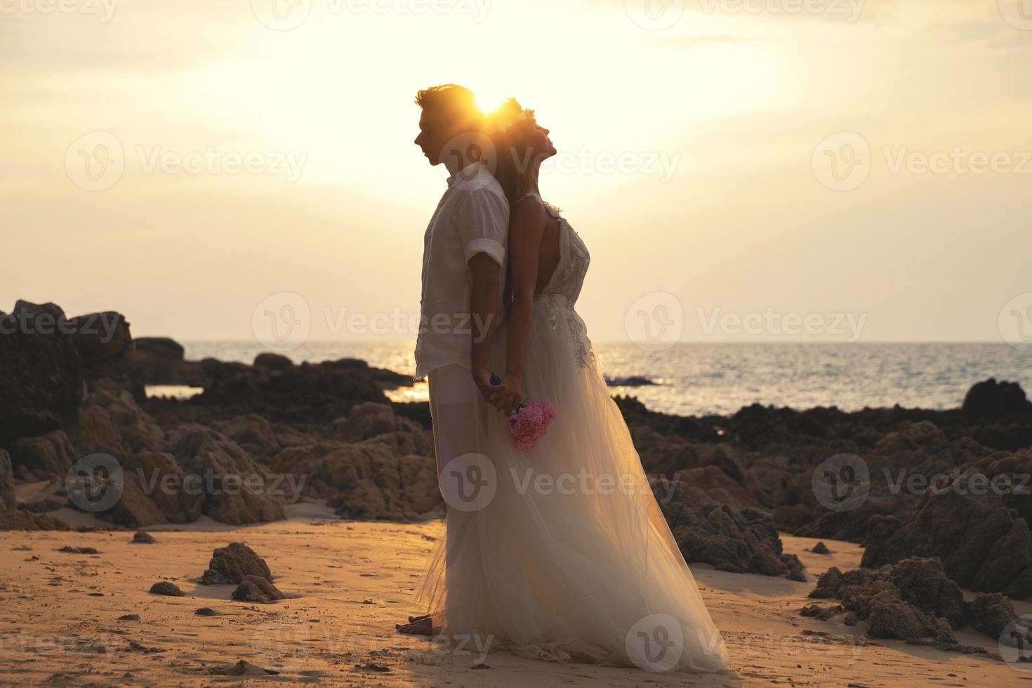 Young married couple in embrace is celebrating their wedding on the beach photo