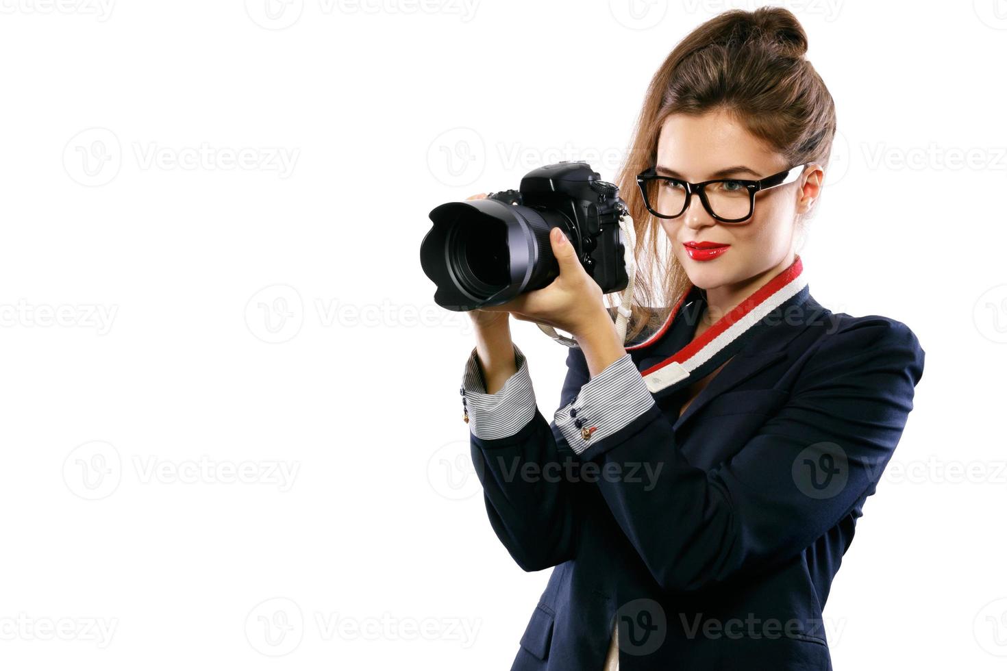 mujer fotógrafa con una cámara réflex digital sobre fondo blanco foto