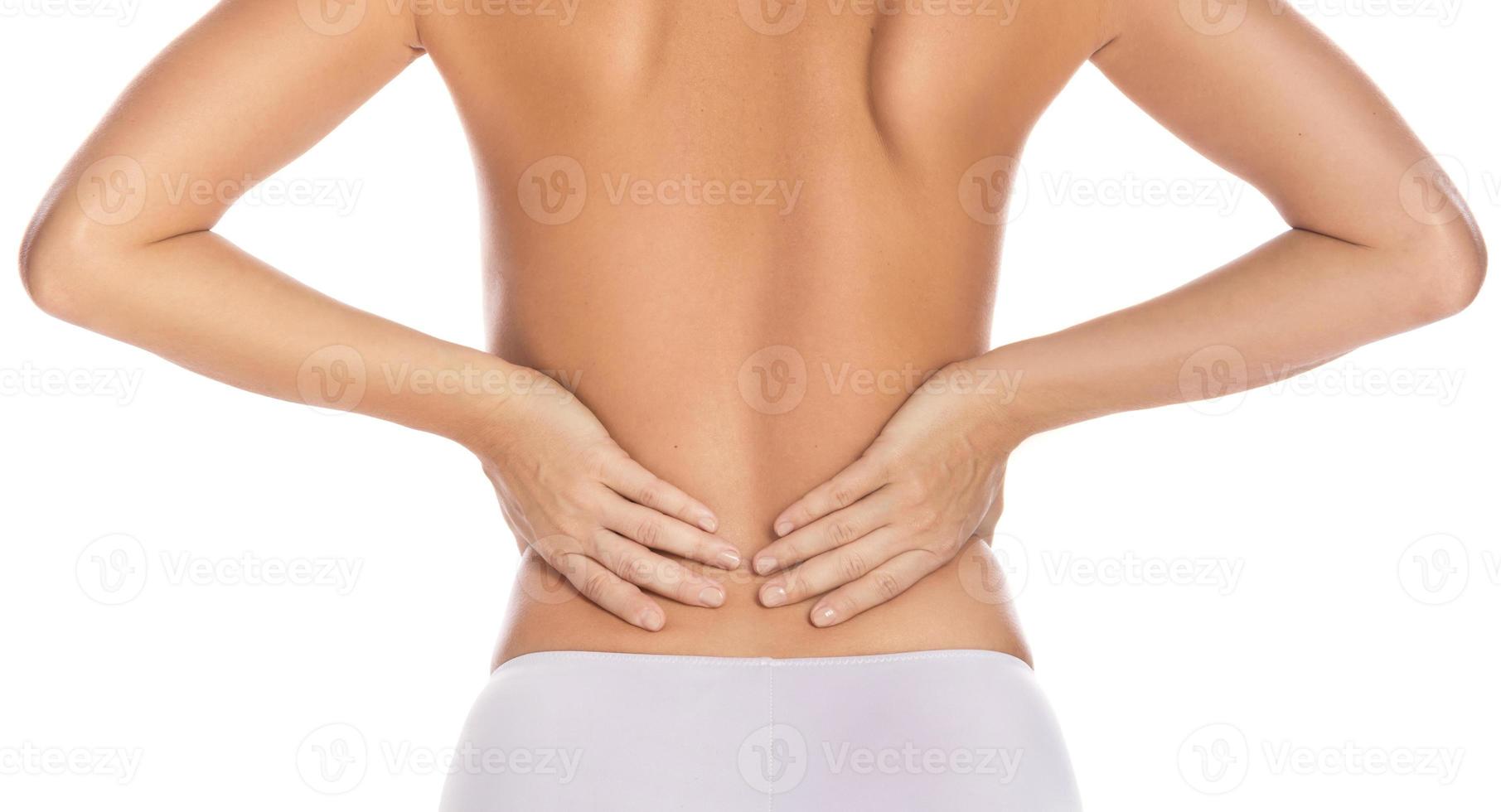 Woman with lower pain back against white background photo