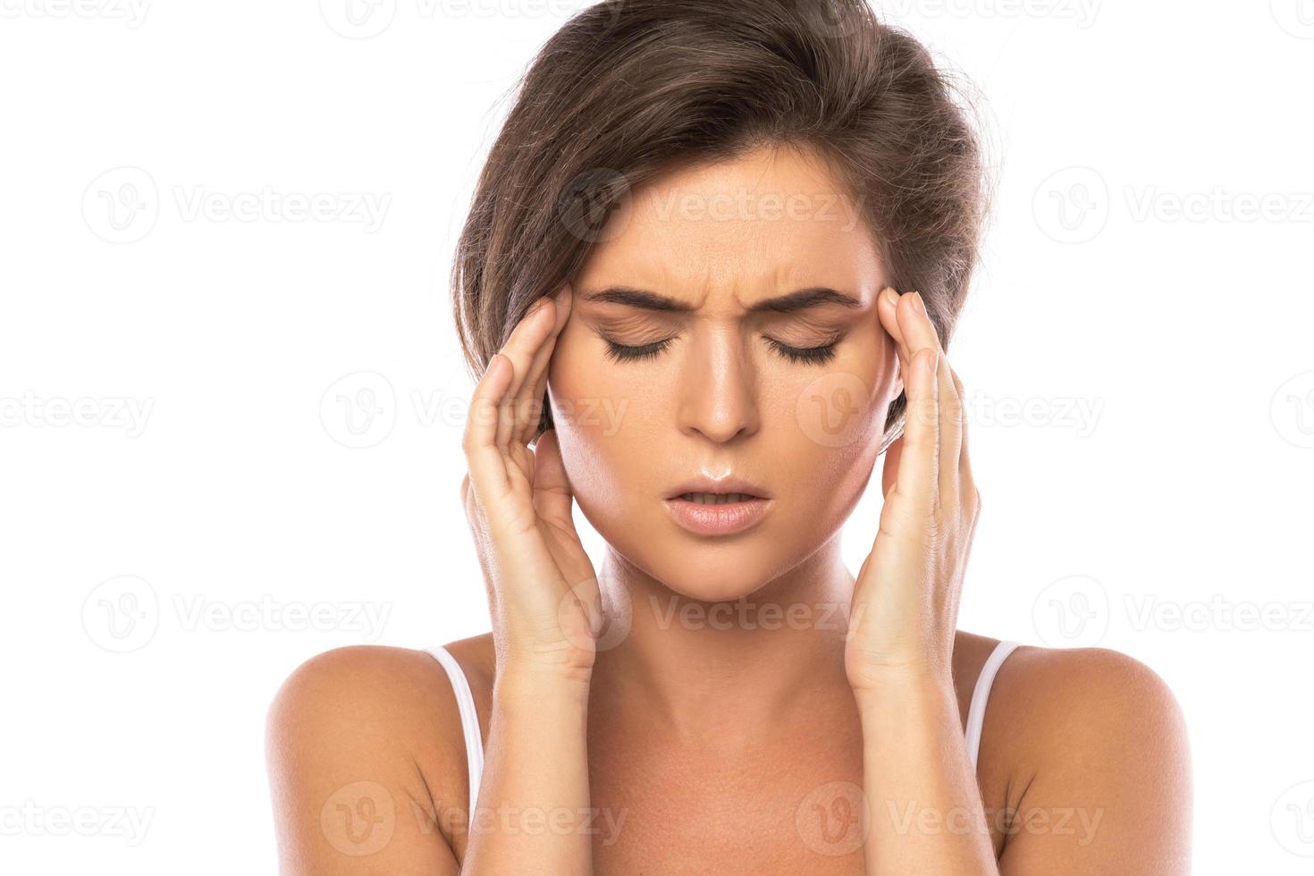 mujer con dolor de cabeza doloroso sobre fondo blanco foto