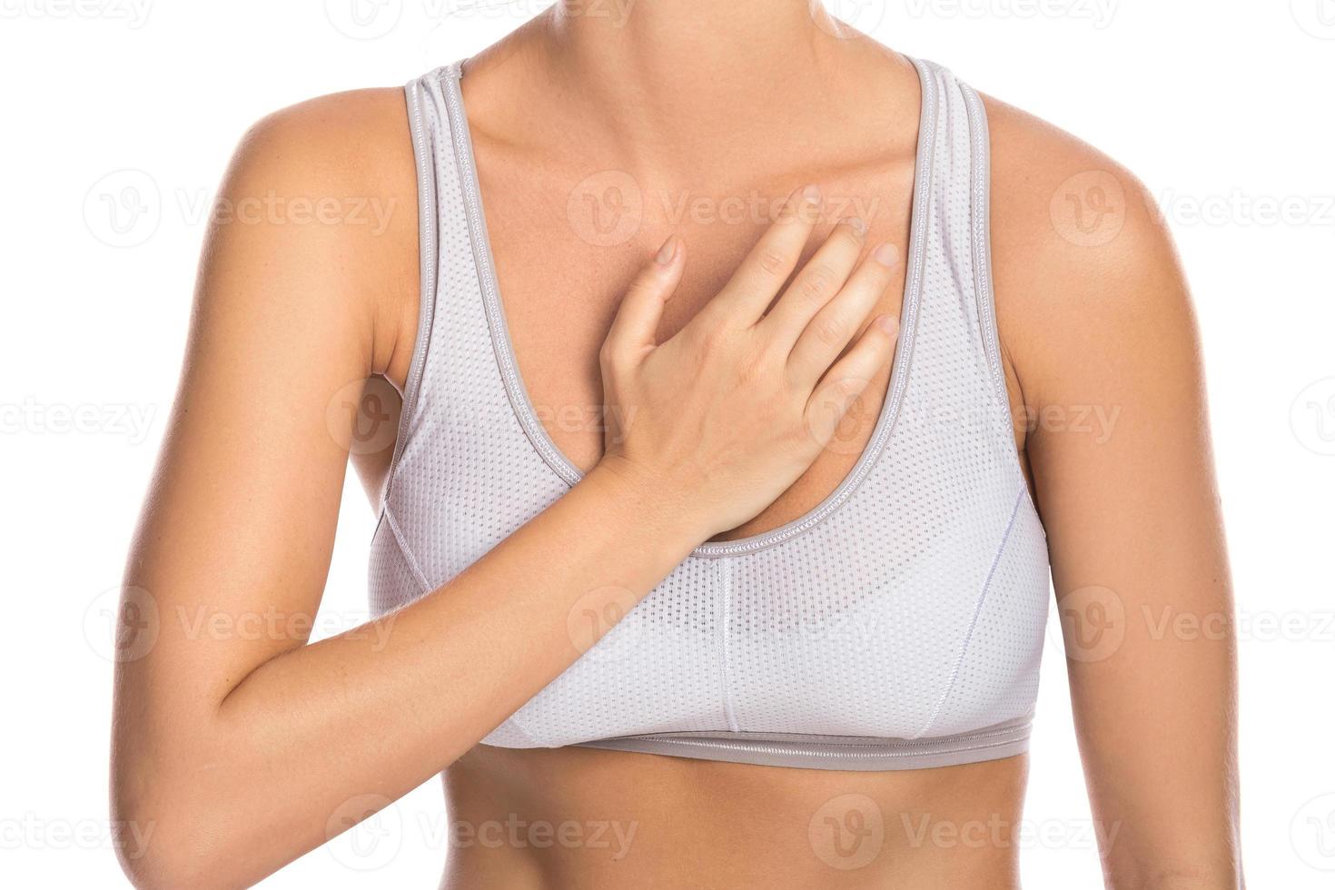 Woman with pain in her chest against white background photo