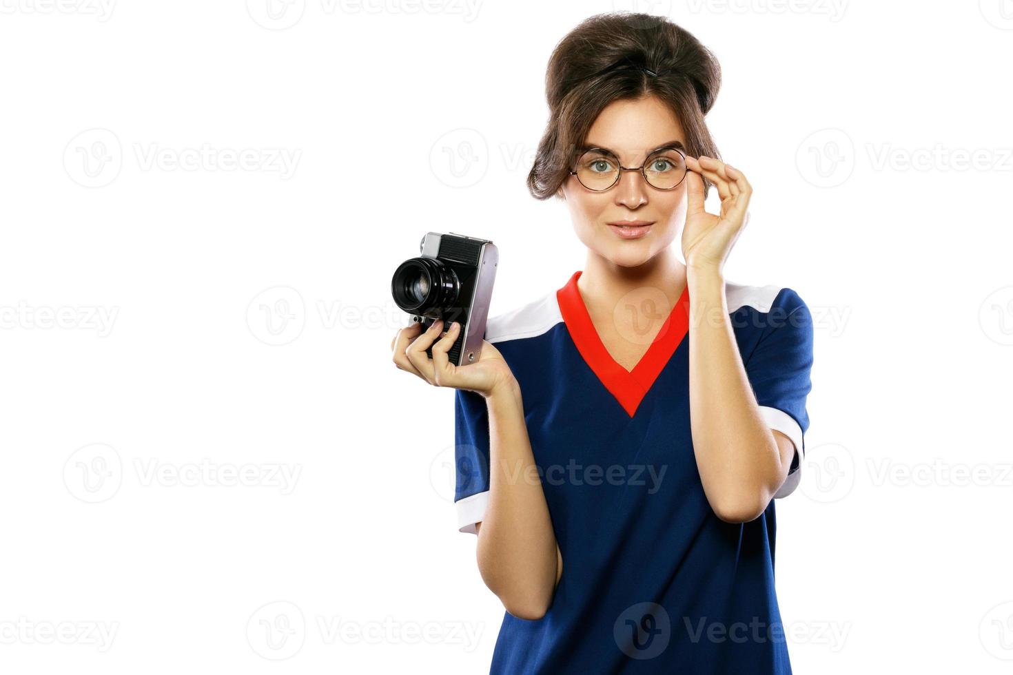 Woman model in vintage look holding retro camera in her hands photo