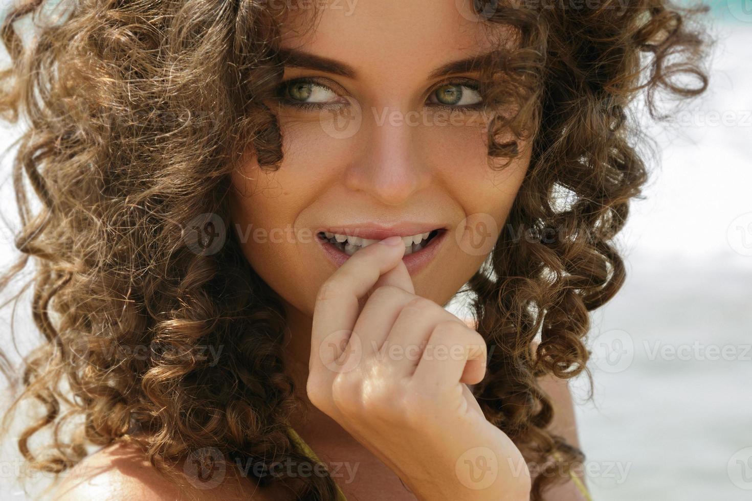 Portrait of beautiful young woman with curly hair photo