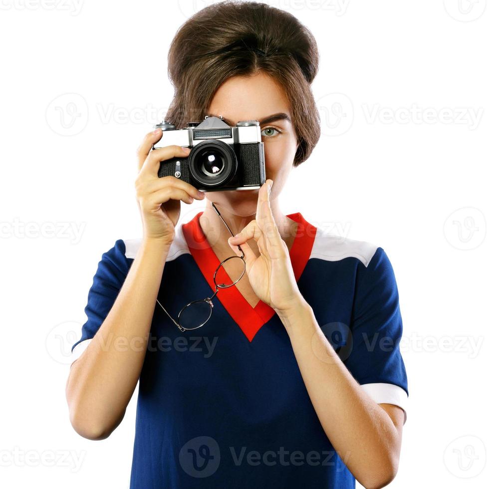 Woman model in vintage look holding retro camera in her hands photo