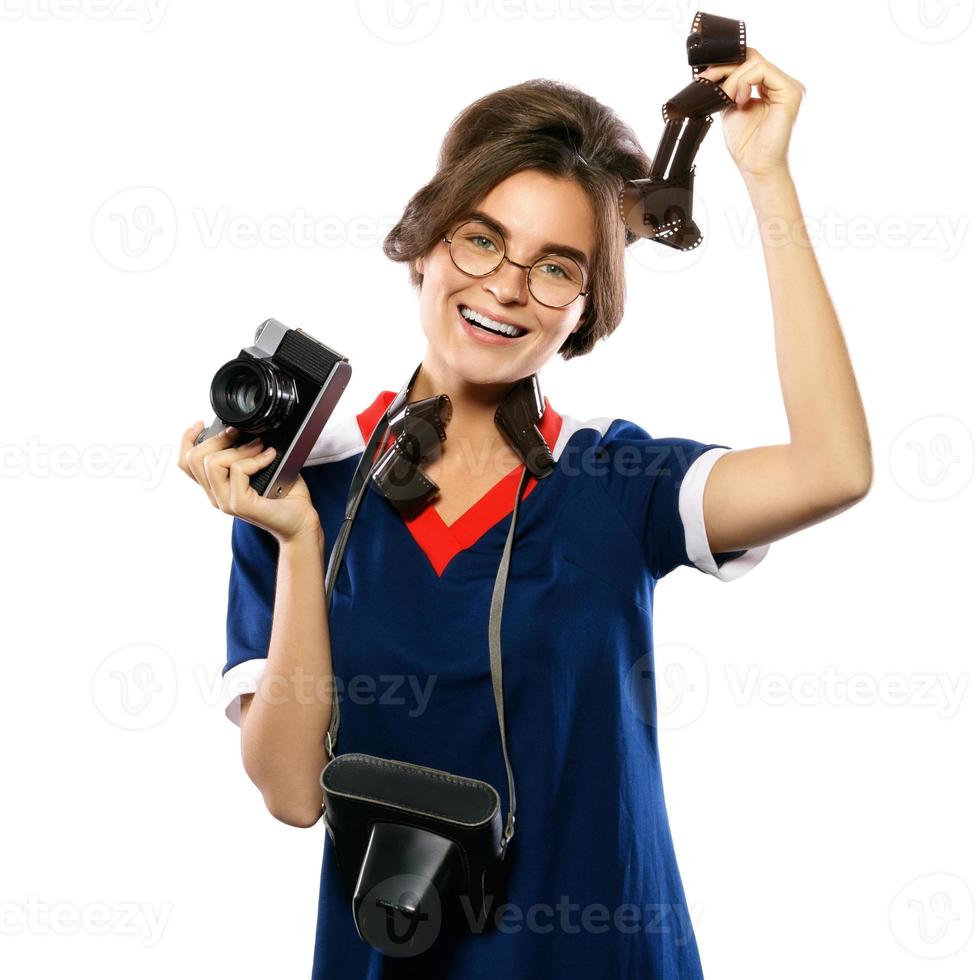 Woman in vintage look holding camera and photographic film in her hands photo