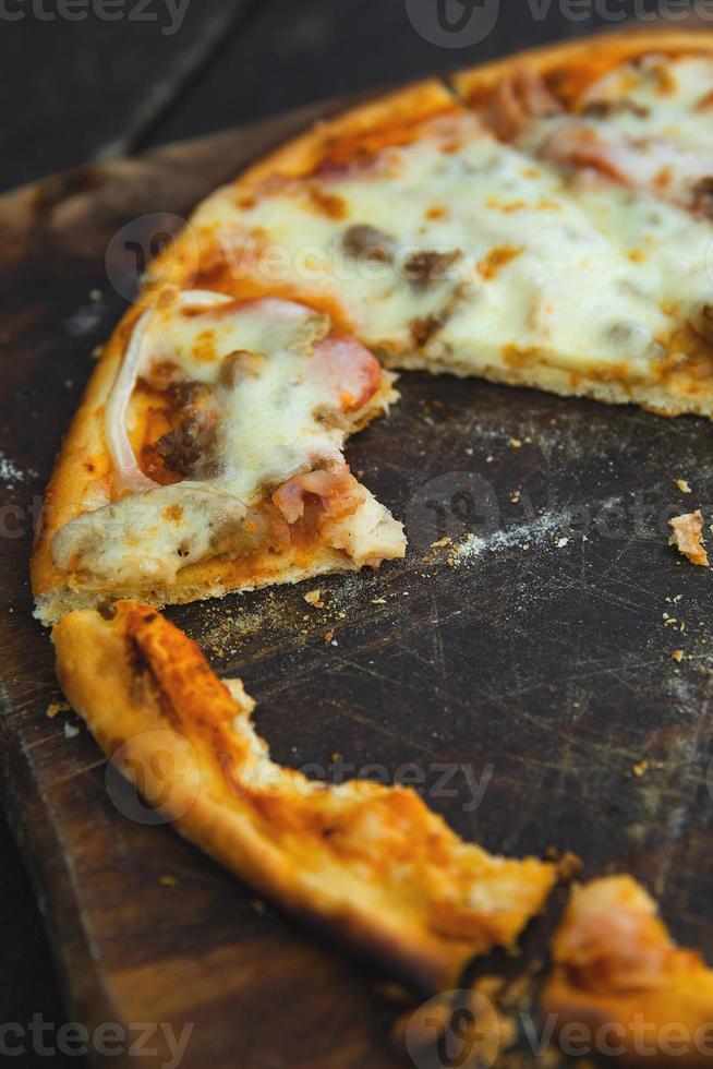 deliciosa pizza al horno en la tabla de madera foto