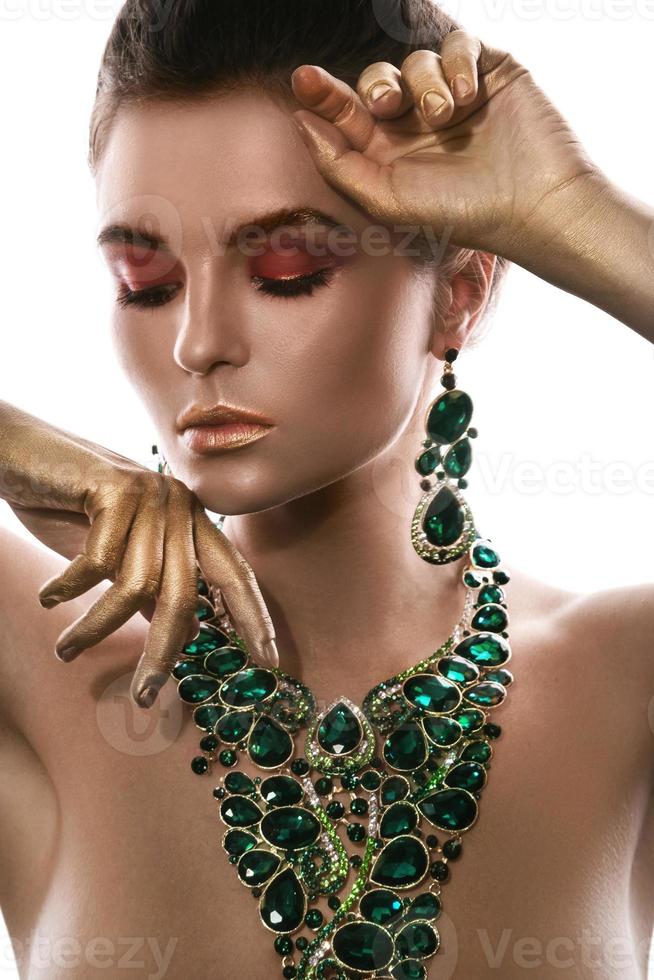 Woman is wearing big beautiful necklace with a lot of gems photo