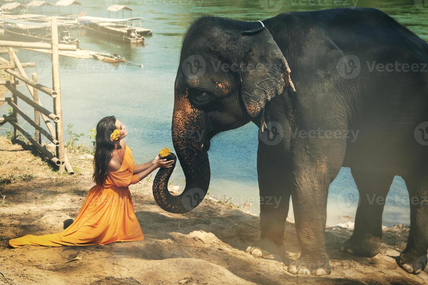 mujer con hermoso vestido naranja y elefante foto