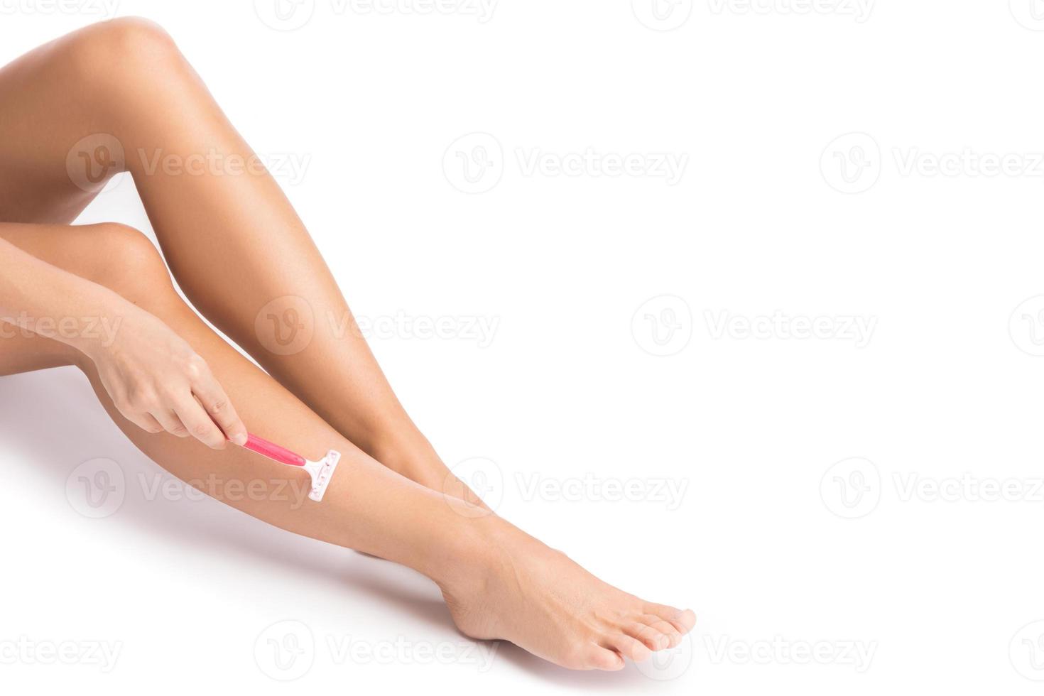 Female legs with shaving razor on white background photo