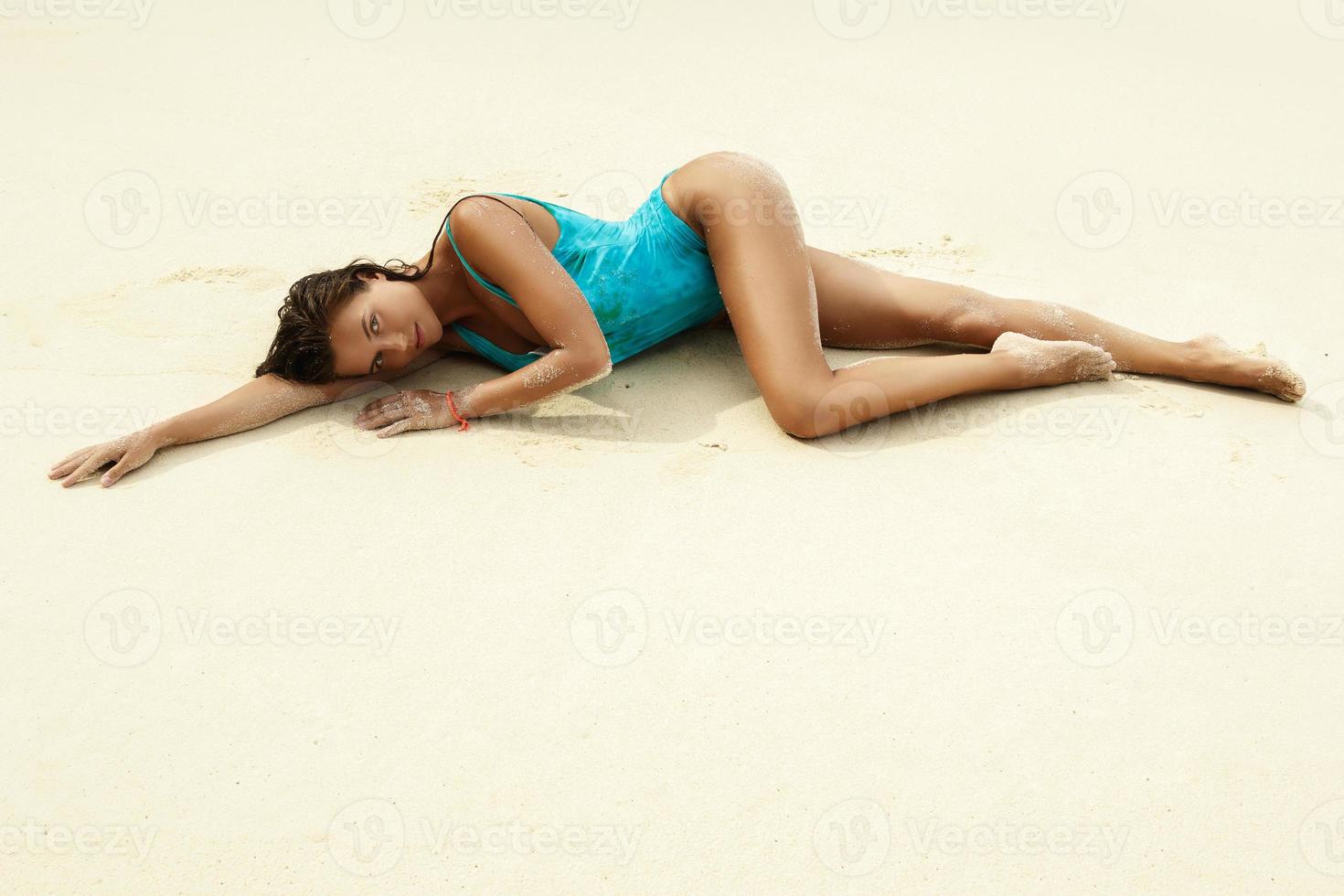mujer sexy cubierta de arena en la playa foto