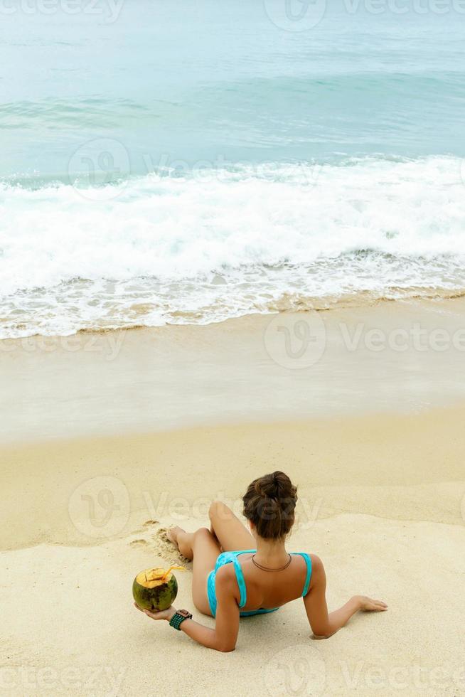 Woman with a coconut on the beach photo