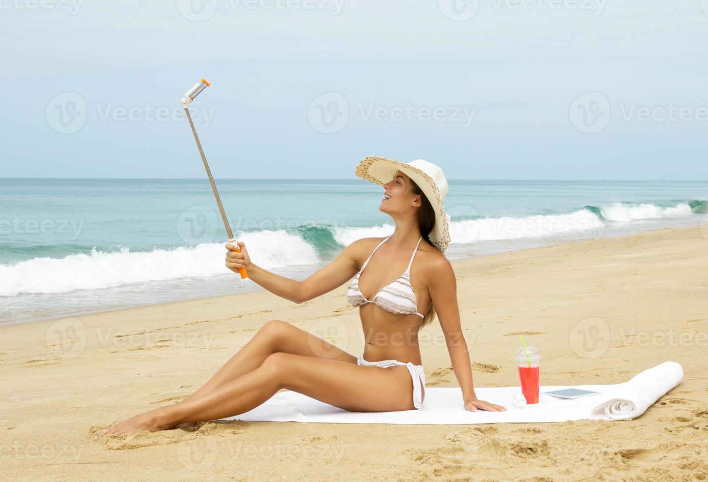 Beautiful woman is taking selfie on the beach photo