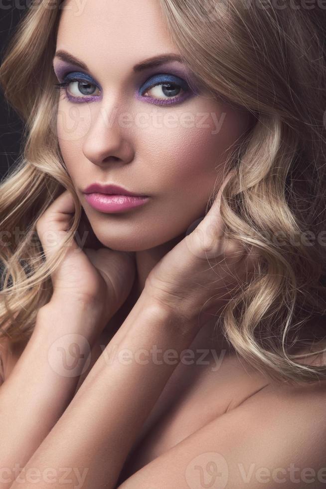 Blonde woman with wavy hair and colorful makeup photo